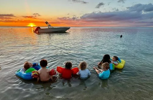 Voyage en famille à l'île maurice enfants dans la mer coucher de soleil